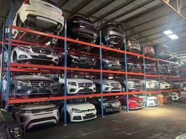 Multi-level storage racks filled with various car makes and models in a warehouse.