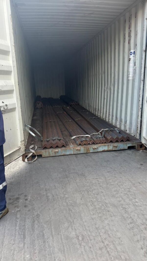 View inside a shipping container loaded with metal angle bars.