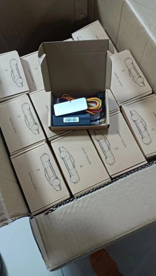 Open carton box with a TK003 GPS tracker and its wiring visible, surrounded by neatly stacked boxes with car outline drawings.